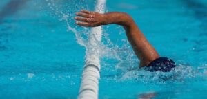 Strength Training to Improve Your Swim in 2026 Swim competition swimmer athlete doing crawl stroke in swimming pool