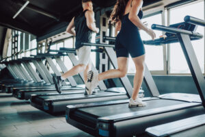 Hispanic and American Couple run treadmill Fitness in the Gym.