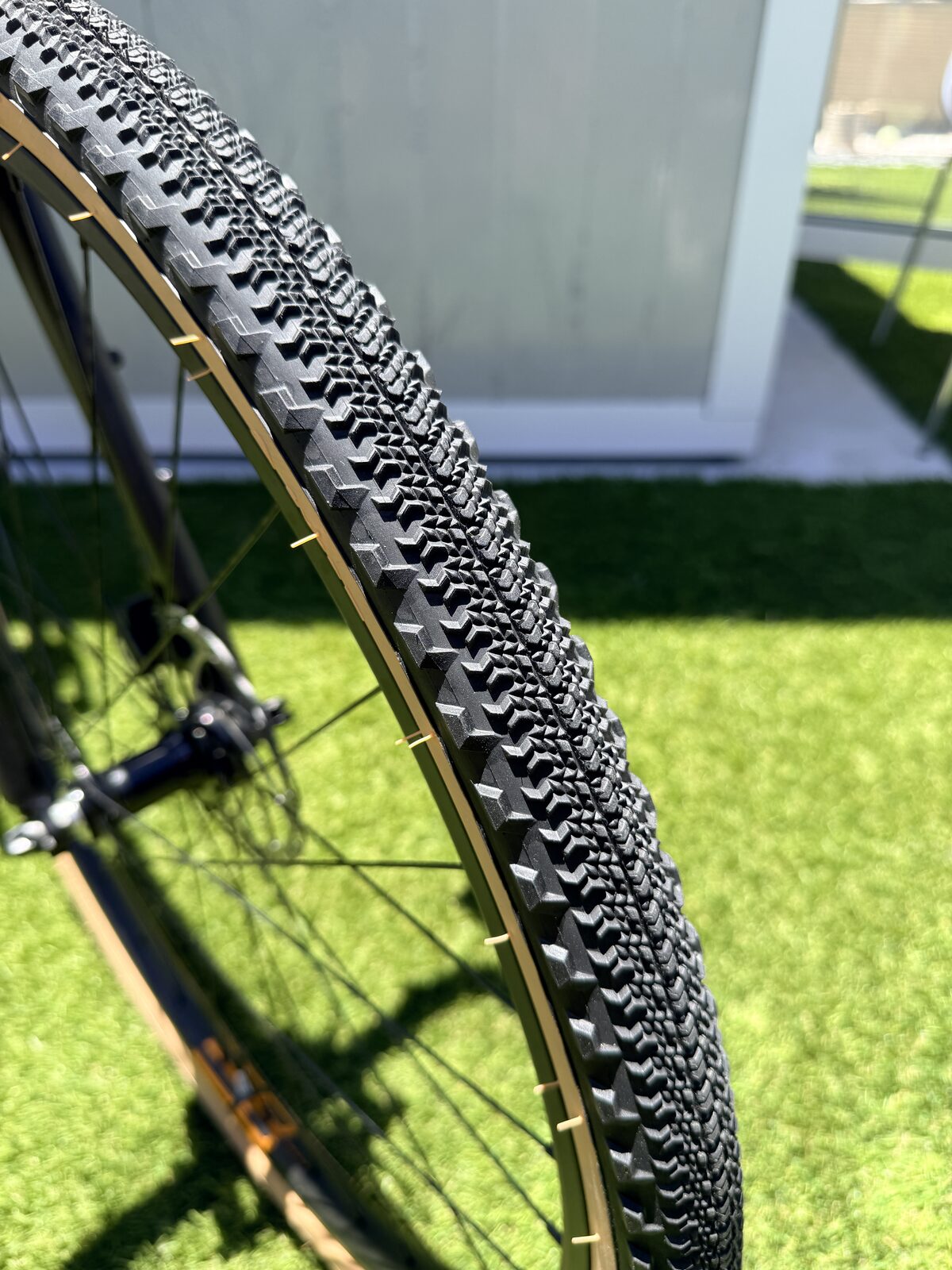 Close-up of the Batch GB.1 700x42mm gravel tire tread, a fast-rolling center with cornering knobs and a tan sidewall.