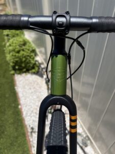 Overhead view of the Batch GB.1 cockpit and head tube, showing the black alloy stem, flared drop bar, and glossy olive-green paint.