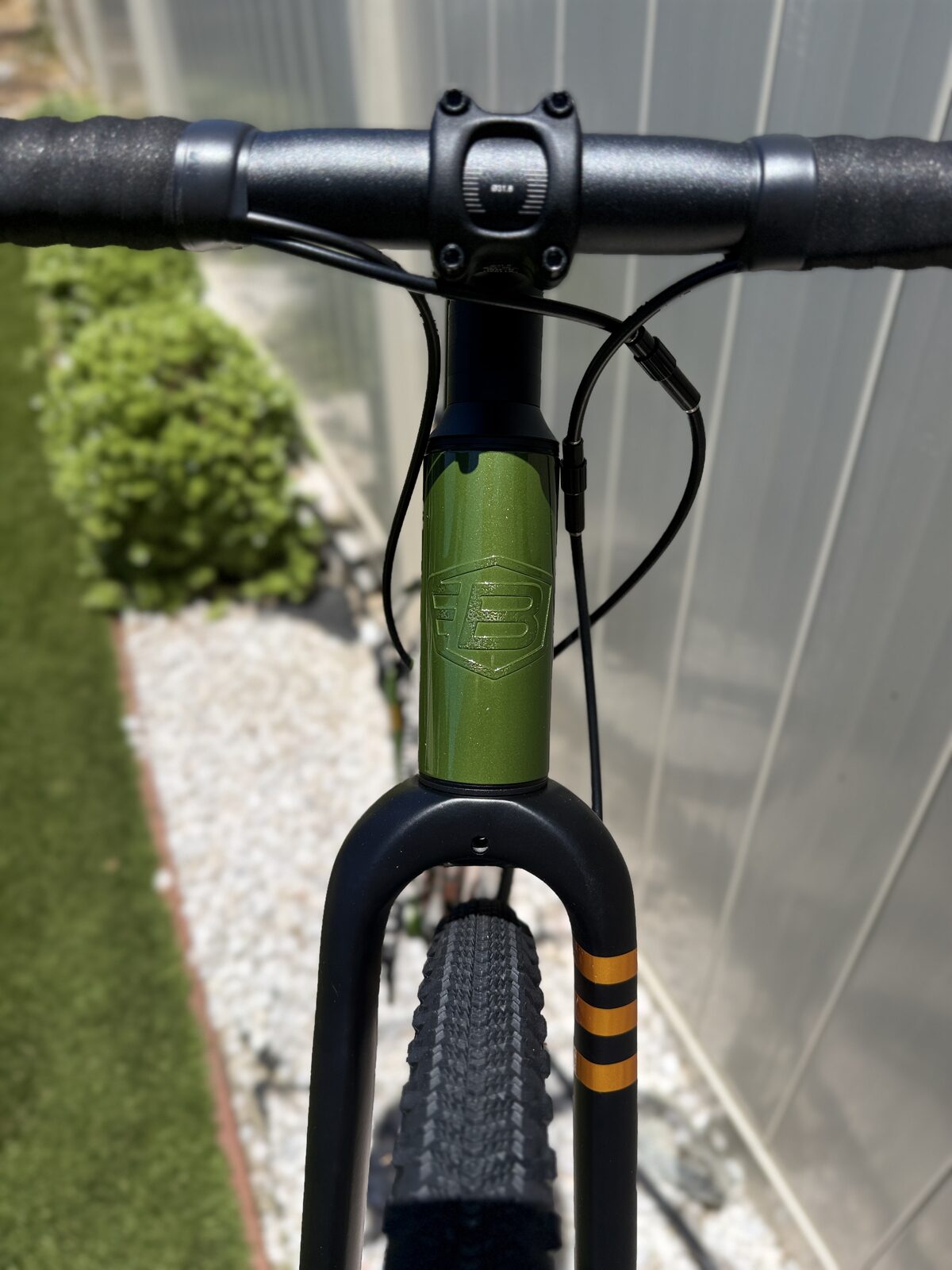 Overhead view of the Batch GB.1 cockpit and head tube, showing the black alloy stem, flared drop bar, and glossy olive-green paint.