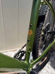 Batch GB.1 seat tube with an orange size sticker reading S / 50cm, showing rear tire clearance around the knobby gravel tire.