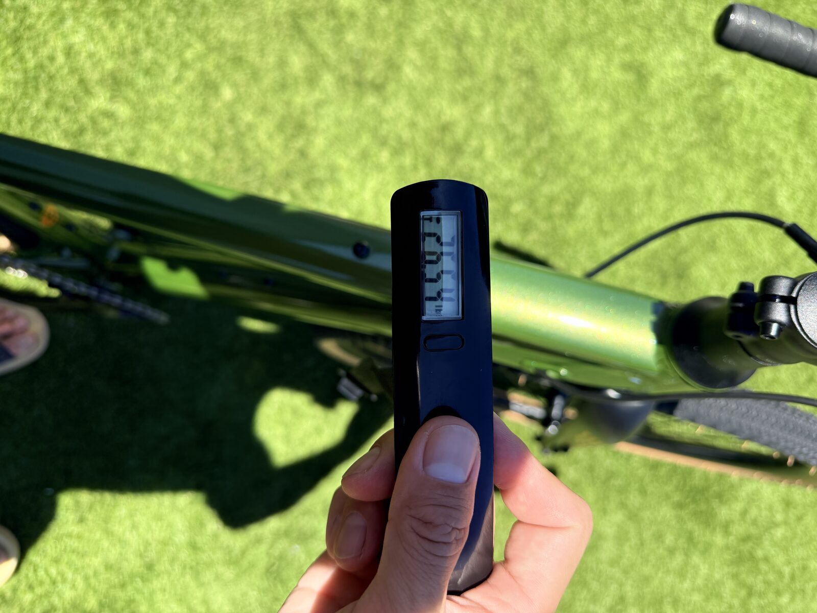 A handheld digital scale reading the weight of the Batch GB.1 gravel bike, with the bike visible below.