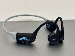 H2O Audio TRI Run bone conduction headphones in the black and gray colorway, photographed on a bench.
